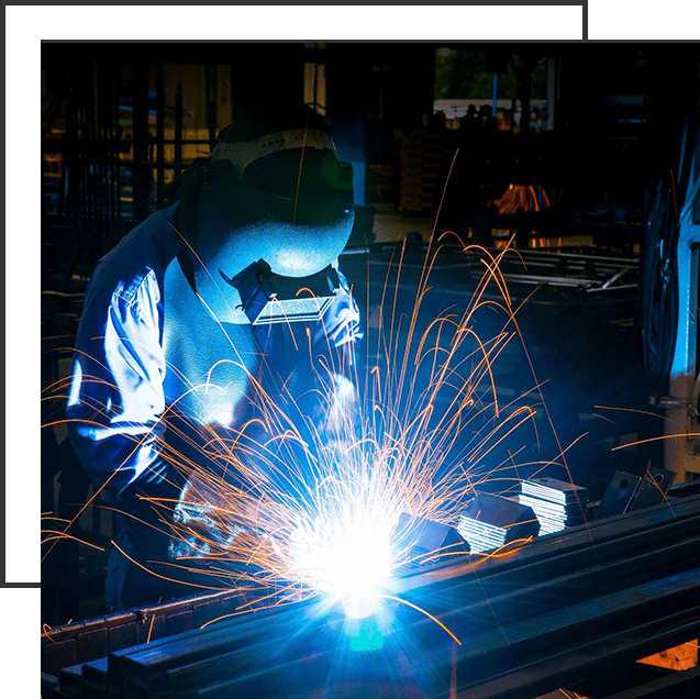 A person welding metal in an industrial setting.