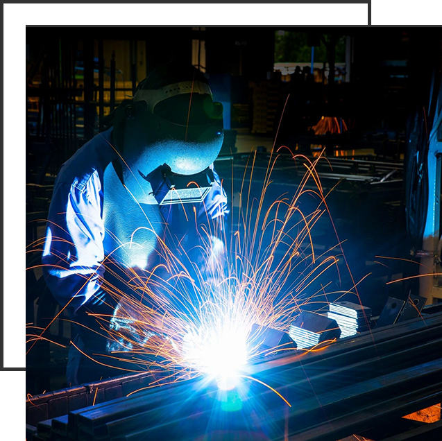 A person welding metal in an industrial setting.