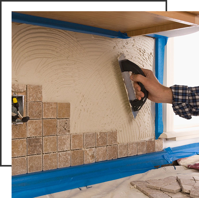 A person is using a spatula to paint the wall.