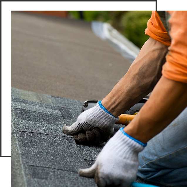 A person with gloves on working on the roof of their home.